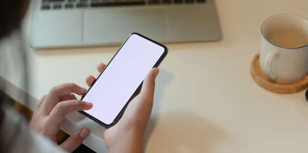 Cropped view of teenage girl holding blank screen smartphone during the relax timeの写真素材