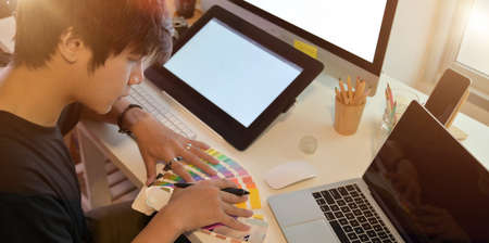 Young professional photographer working on his project with colour swatchesの写真素材