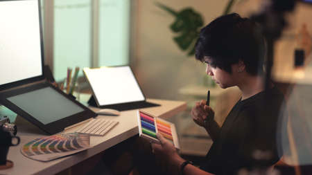 Young motivated male photographer choosing the colour for his photoの写真素材