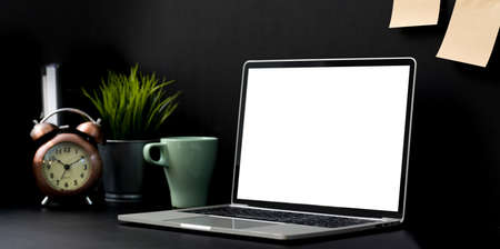 Dark luxury workplace with blank screen laptop computer with office supplies and decorationsの写真素材