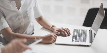 Close-up view of young businesswoman working on her project with her partnerの写真素材