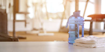 Towels and sport bottle with copy space blurred gym backgroundの写真素材
