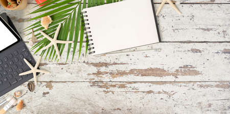 Summer beach concept : blank notebook and office supplies with shell decorations on vintage wooded tableの写真素材
