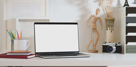 Blank screen laptop computer with office supplies and decorations in designer workplaceの写真素材