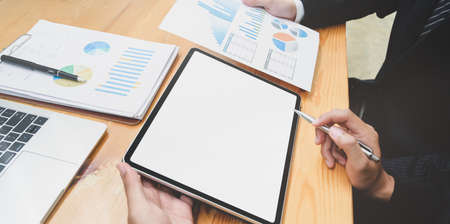 Motivated businessman explaining his plan to his partner with charts and graphsの写真素材