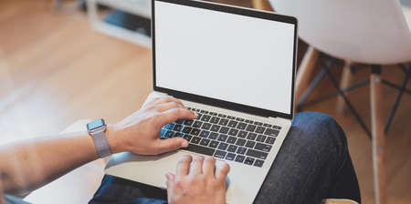 Close-up view of male freelancer editing his project with laptop computerの写真素材