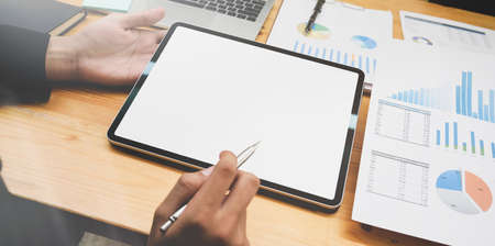 Close-up view of motivated businessman preparing his project with blank screen tablet in meeting roomの写真素材