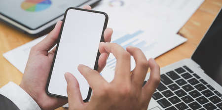 Close-up view of young businessman searching for idea in blank screen smartphone