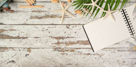 Summer beach concept : rustic wooden workplace with notebook and decorations