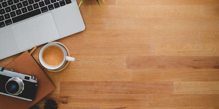 Photographer's comfortable workplace with laptop and vintage camera on wooden table