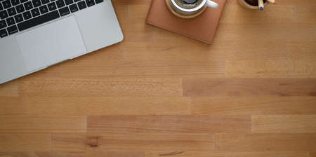 Overhead shot of creative workplace with laptop and copy space on wooden table backgroundの写真素材
