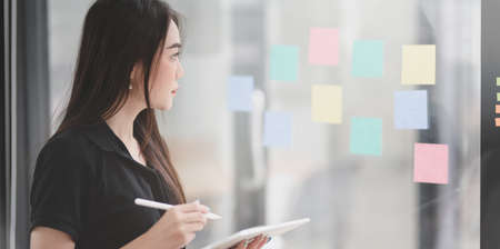 Young professional female freelancer collecting the idea from sticky notes