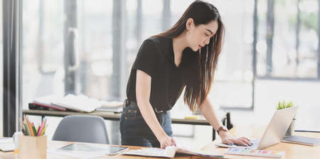 Asian businesswoman working on the project with laptop in modern working spaceの写真素材