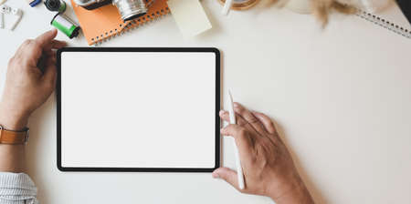 Top view of male photographer working on  his project with blank screen tabletの写真素材