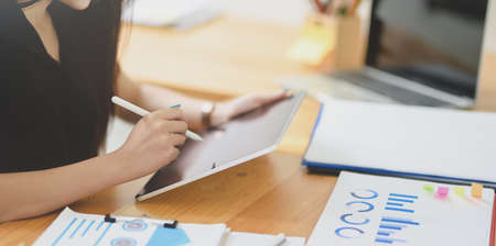 Close-up view of beautiful young businesswoman working on her project in comfortable officeの写真素材