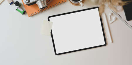 Top view of motivated photographer workplace with blank screen tablet and office accessoriesの写真素材