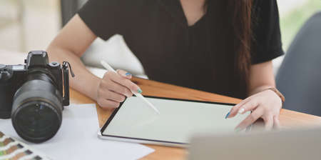 Cropped view of female graphic designer working on her project with tablet