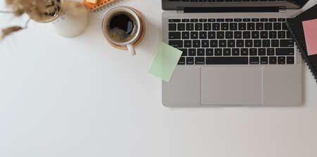 Top view of freelancer's workplace with laptop computer and coffee cup in minimal style workplaceの写真素材