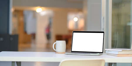 Stylish home-office with open blank screen laptop computer with copy spaceの写真素材