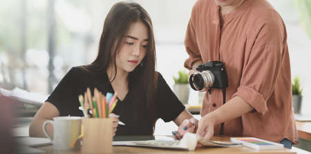 Group of young motivated designer discussing the project together in modern office roomの写真素材