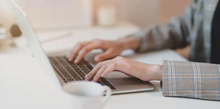 Young businesswoman typing on laptop computer in comfortable office