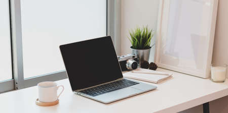 Contemporary photography workplace with laptop computer and mock up frameの写真素材
