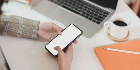 Close-up view of businesswoman looking for new issues on blank screen  smartphone for her projectの写真素材
