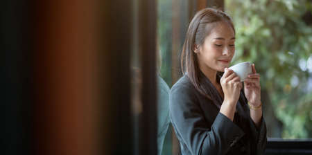 Beautiful businesswoman enjoying coffee during the coffee break in the officeの写真素材