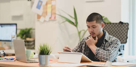 Young professional graphic designer preparing the project for the meetingの写真素材