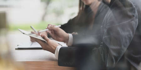 Close-up view of motivated  businesspeople discussing the project together in modern office roomの写真素材