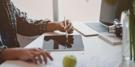Professional male designer working on his project while writing the idea on tabletの写真素材