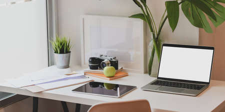 Modern designer workplace with blank screen laptop computer, tablet and office suppliesの写真素材