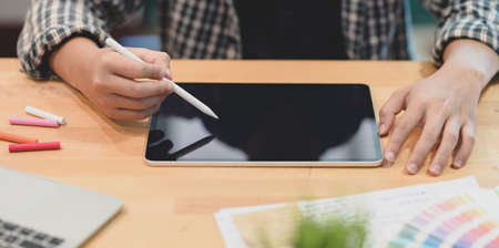 Cropped view of young graphic designer planing his project on tablet in modern office roomの写真素材