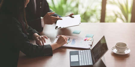 Close-up view of passionate business partner working together with graphs in office room