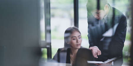 Young businessman explaining his idea to his female coworker in the modern office room