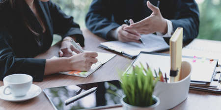Close-up view of young professional business team brainstorming their strategy together in office roomの写真素材