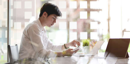 Young businessman working on his project with laptop computer in comfortable workplaceの写真素材