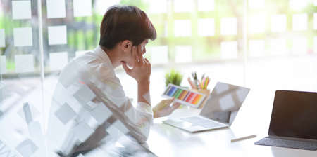 Young professional male graphic designer working on colour in comfortable office room