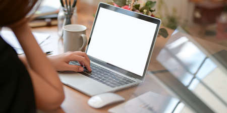 Cropped view of professional businesswoman typing on laptop computer while working on her project