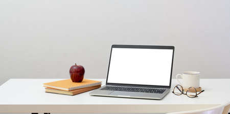 Minimal workplace concept : open blank screen laptop with office supplies and decorations