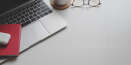 Top view of trendy workplace with office supplies and copy space on white table backgroundの写真素材