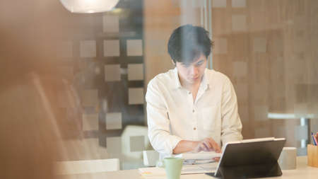 Young male freelancer working on his strategy for the next project in modern workplaceの写真素材