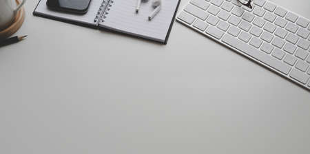 Top view of minimal workplace with office supplies and copy space on white table backgroundの写真素材