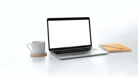 Stylish minimal workplace with open blank screen laptop, coffee cup and notebook with white backgroundの写真素材