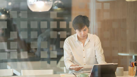 Professional male freelancer working on his strategy for the next project in modern workplaceの写真素材