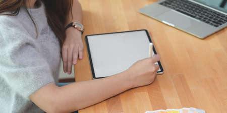 Cropped view of a young female freelancer writing her idea on tablet for her upcoming project
