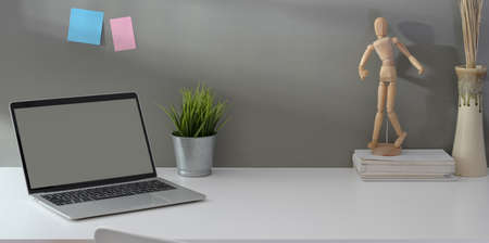Open blank screen laptop computer with vintage camera and office supplies in minimal workplaceの写真素材