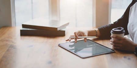 Close-up view of female freelancer writing her idea concepts on tablet in comfortable working space