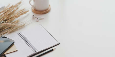Open notebook and office supplies on white table desk background in minimal workplace styleの写真素材