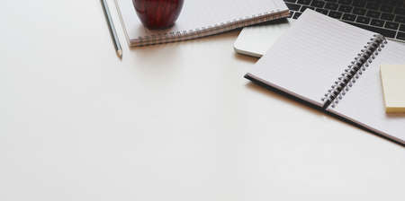 Open notebook and office supplies on white table desk background in modern workplace styleの写真素材